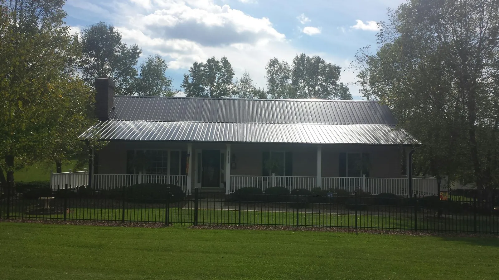 Gray metal roof on a brick ranch with a full width front porch — Gutter Guard Installation work by our crew in Ewing
